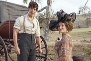 A man and a woman stand by a wagon