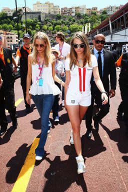 (L-R) Poppy Delevingne and Cara Delevingne walk down the pit lane before the start of the Monaco Formula One Grand Prix at Circuit de Monaco on May 24, 2015 in Monte-Carlo, Monaco.