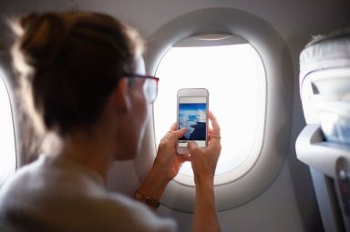 Woman taking photo out of plane window