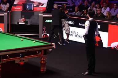 A protester halts the World Snooker Championship final match between Wu Yize and Shaun Murphy