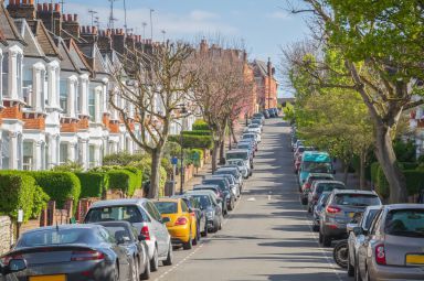 Typical London street lined with terraced houses and parked cars