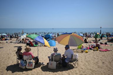 Sunbathers relax in the sunshine on Bournemouth beach on the south coast of England on May 26, 2026, as heatwave conditions spread to parts of southeast England and London. Britain registered on Tuesday its hottest-ever May temperature on record, with the mercury rising to 35C near the capital. (Photo by JUSTIN TALLIS / AFP via Getty Images)