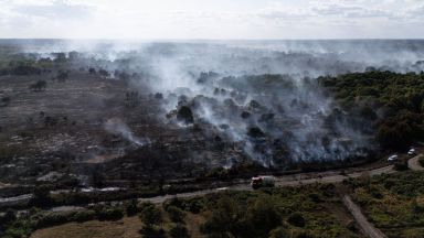 Smoke rises from the smouldering remains of a wildfire at Dunwich Heath, near Leiston, 